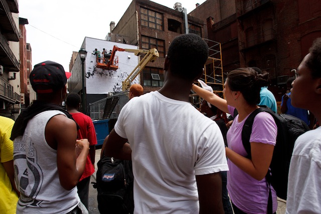 An art class from Mural Arts visits Vhils on site